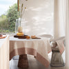 Beige Jardin d'Eden napkin by Le Jacquard Francais, elegantly displayed on a dining table with a modern vase and decor.