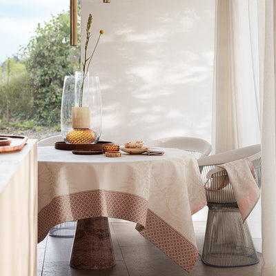 Beige Jardin d'Eden napkin by Le Jacquard Francais, elegantly displayed on a dining table with a modern vase and decor.