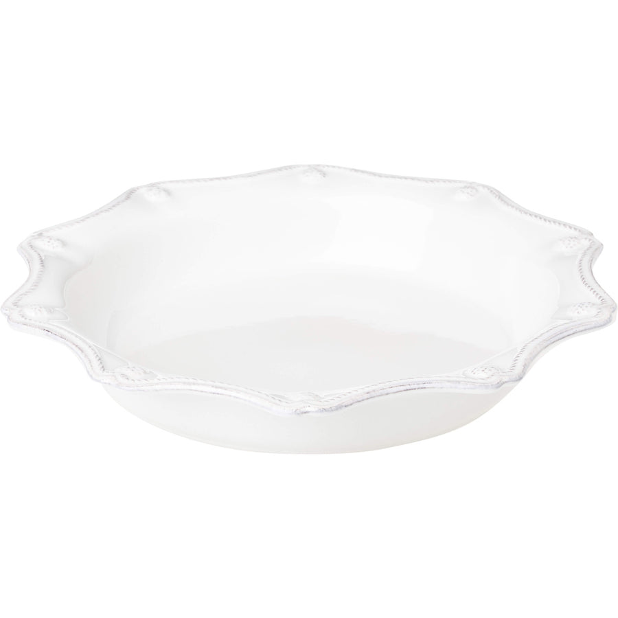 White ceramic pie or quiche pan with a scalloped edge and intricate berry and thread detailing.