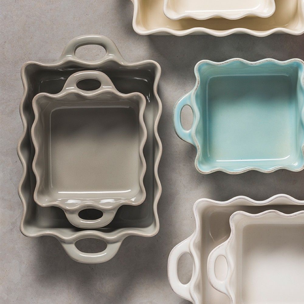 Casafina Cook & Host medium ruffled rectangular baker in various colors stacked together on a neutral surface.
