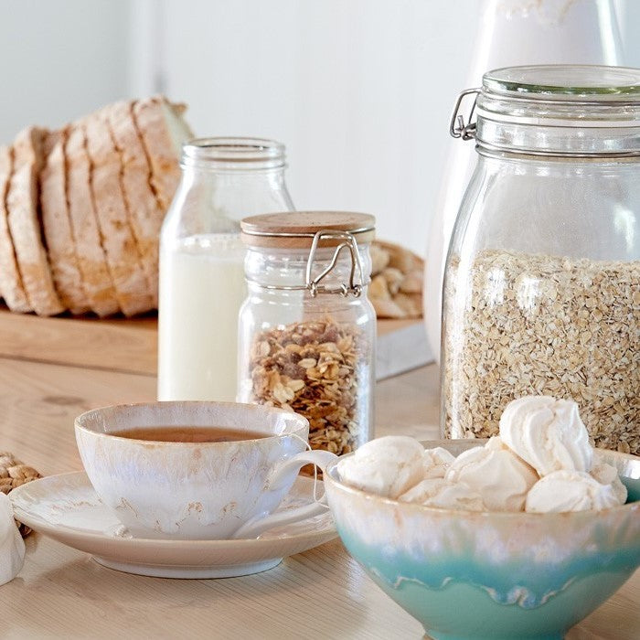 Casafina Taormina cereal bowl filled with meringues, surrounded by breakfast items like granola, milk, and bread.