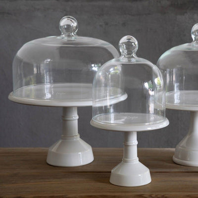 Three elegant Casafina glass domes on white pedestals, showcasing a classic design for displaying desserts or pastries.