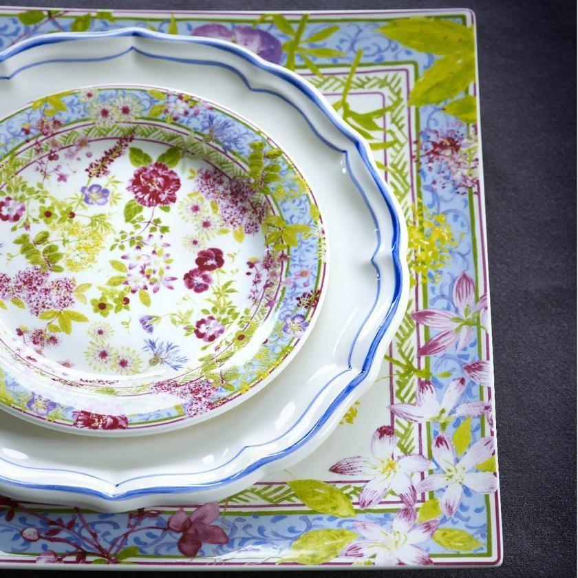 Gien Millefleurs Creamer displayed with floral-patterned plates on a textured surface, showcasing vibrant colors and intricate designs.