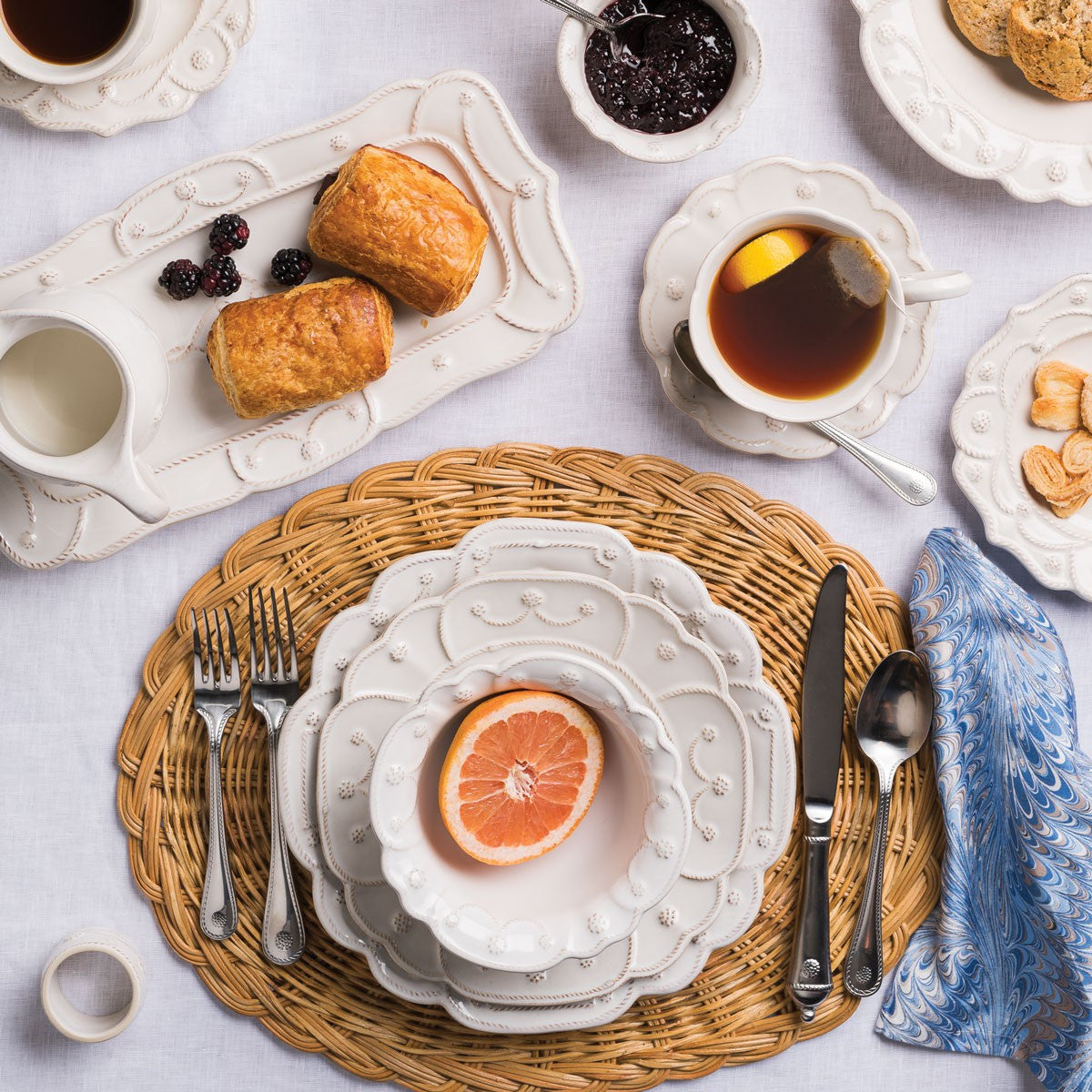 Juliska Jardins du Monde Heligan Dessert Plate displayed on a woven placemat with breakfast items, including tea, pastries, and fruit.