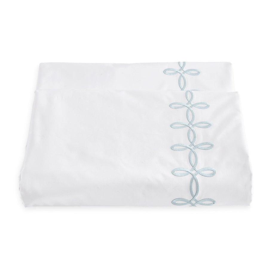 Matouk Gordian Knot Duvet Cover featuring a white fabric with delicate blue embroidered knot design along the edge.