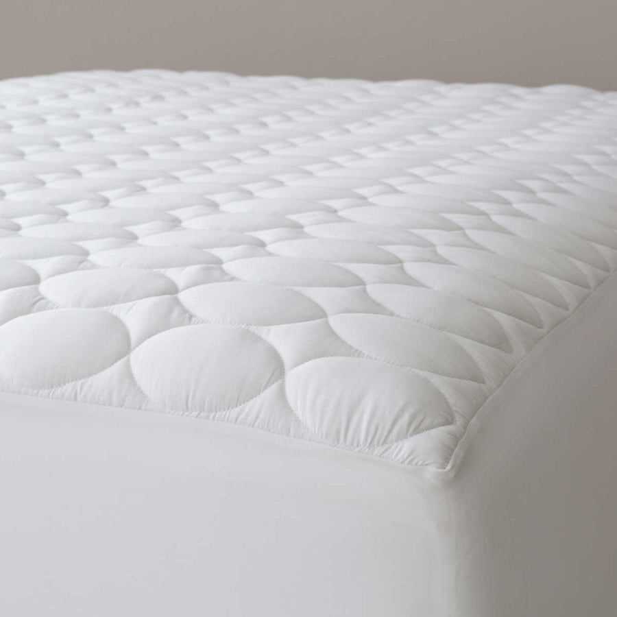 White quilted mattress pad featuring a soft, cloud-like design for added comfort and protection. Ideal for enhancing sleep quality.
