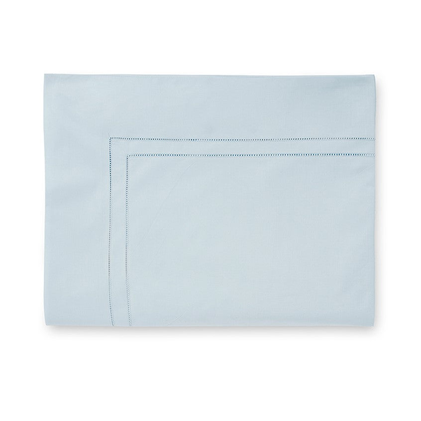 Sferra Finna flat sheet in soft blue with delicate stitched detailing along the edges, showcasing elegant craftsmanship.