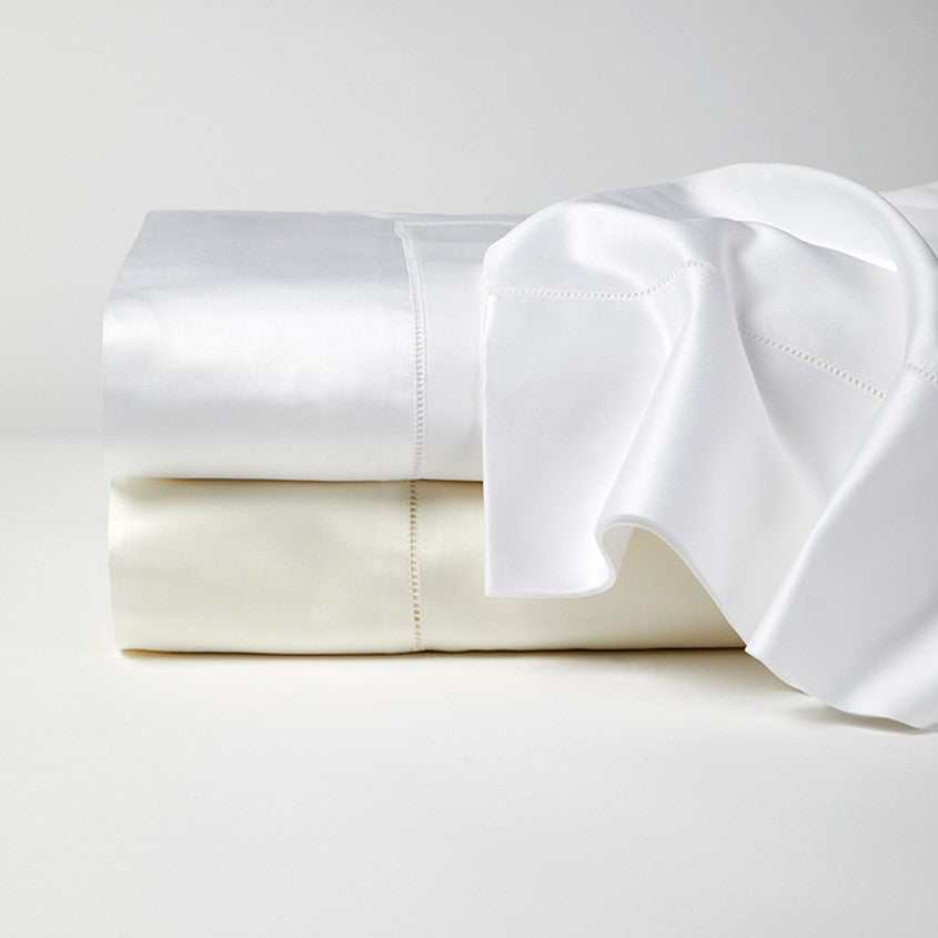 Sferra Giza 45 sateen flat sheet in white and ivory, showcasing smooth fabric and elegant stitching details.