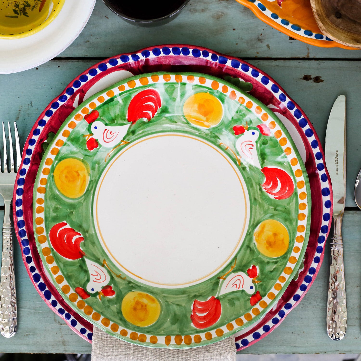 Vietri Campagna Pesce Pasta Bowl features a colorful design with roosters and yellow accents on a green background.